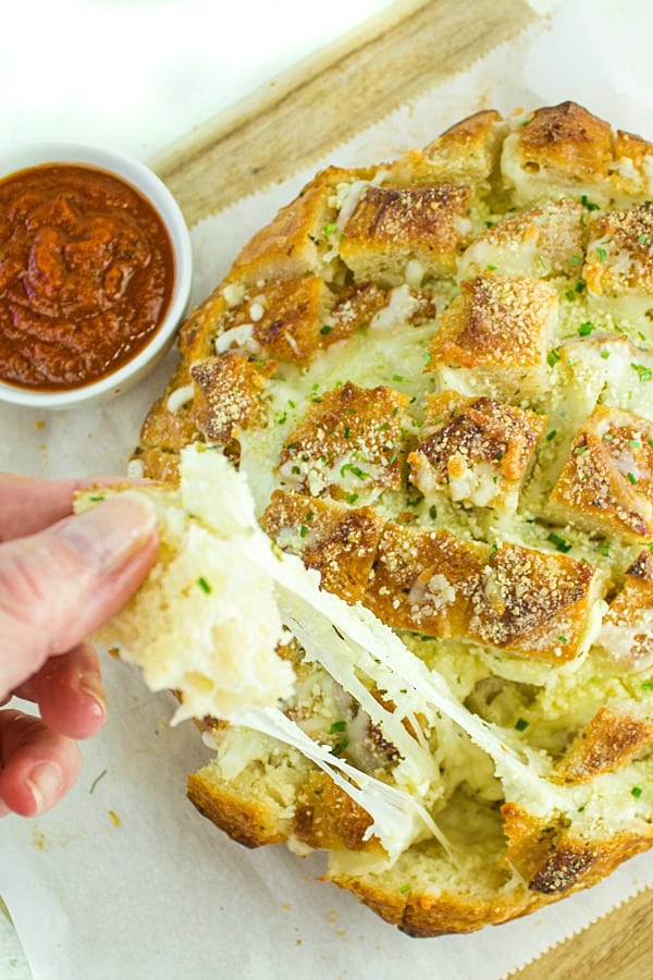 Pull apart three cheese garlic bread is a round sourdough loaf drizzled with garlic butter and stuffed with melting cheese. Crusty, and gooey hot bread made easy in under 30 minutes. #mustlovehomecooking