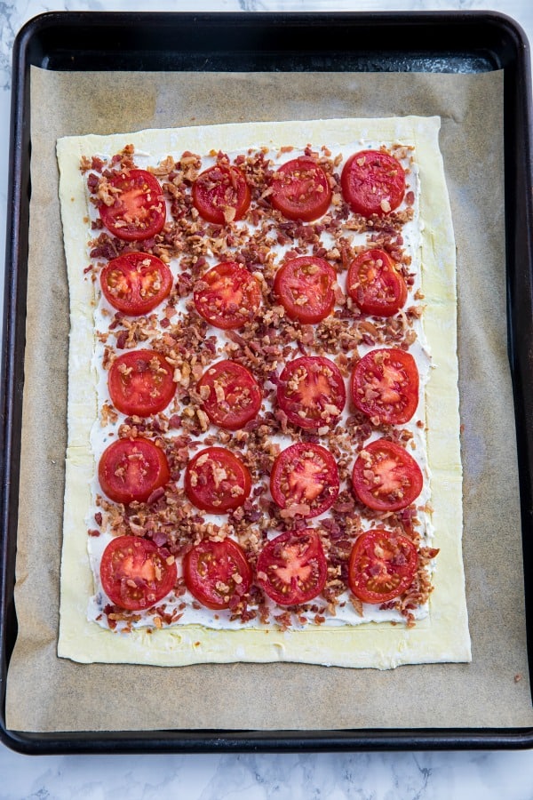 puff pastry and tomato tart filling on baking sheet