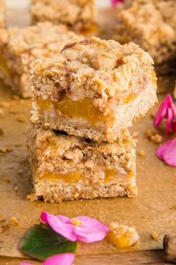 Buttery and decadent, these simple Cinnamon Spice Peach Crumb Bars with oats and spice are just in time for this seasonal fruit. #mustlovehomecooking