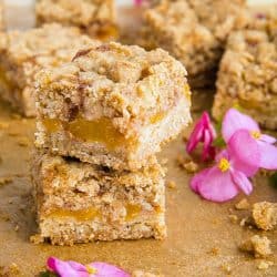 Buttery and decadent, these simple Cinnamon Spice Peach Crumb Bars with oats and spice are just in time for this seasonal fruit. #mustlovehomecooking