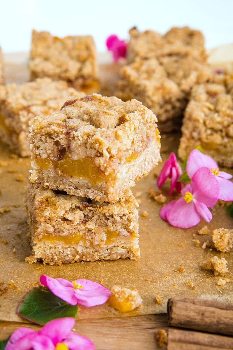 Buttery and decadent, these simple Cinnamon Spice Peach Crumb Bars with oats and spice are just in time for this seasonal fruit. #mustlovehomecooking