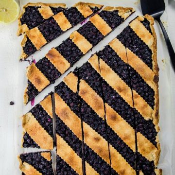 Blueberry Slab Pie is fresh blueberries, cinnamon and lemon juice baking into a buttery and crisp shortbread crust. Easily cuts into bars and feeds a crowd! #mustlovehomecooking