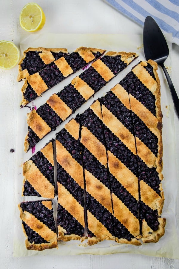 Blueberry Slab Pie is fresh blueberries, cinnamon and lemon juice baking into a buttery and crisp shortbread crust. Easily cuts into bars and feeds a crowd! #mustlovehomecooking