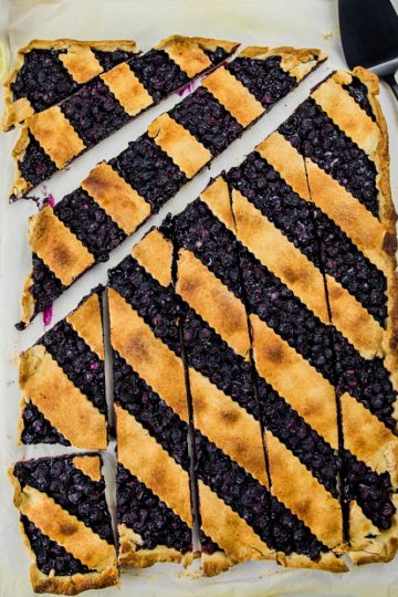 Blueberry Slab Pie is fresh blueberries, cinnamon and lemon juice baking into a buttery and crisp shortbread crust. Easily cuts into bars and feeds a crowd!