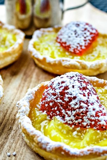 Cool, tangy and dotted with fresh strawberry this simple mini lemon tart dessert takes only 4 easy ingredients and no special pans to make them! #mustlovehomecooking