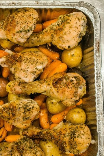 Baked up juicy and full of garden herb flavor, this freezer meal with chicken drumsticks, potatoes, carrots and savory sauce is a tasty family favorite. #mustlovehomecooking