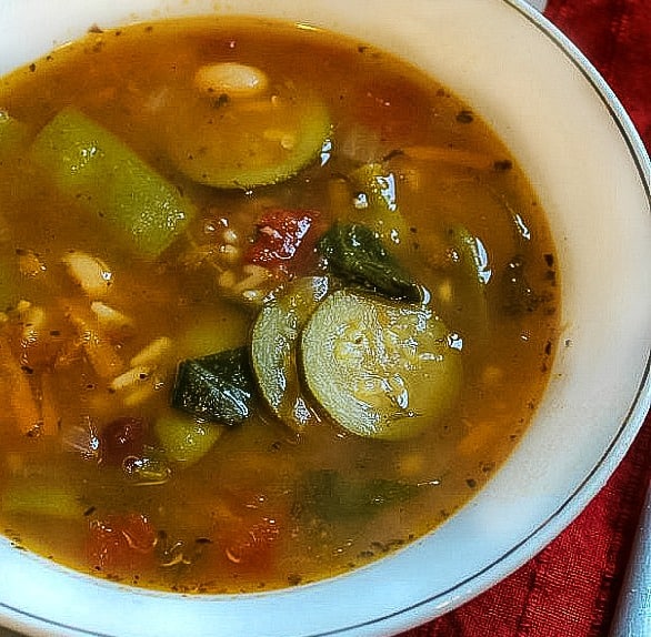 Copycat Olive Garden Minestrone Soup made with zucchini, beans and pasta has all the flavor of the original. Healthy and vegetarian too! #mustlovehomecooking