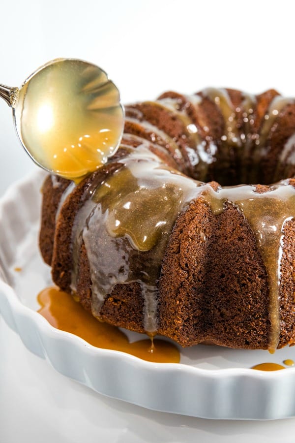 pouring toffee glaze over baked pumpkin cake