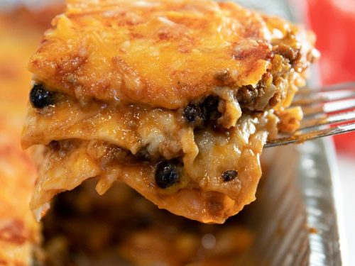 Easy Mexican Beef Lasagna - it's a Taco Tuesday favorite with layers of seasoned ground beef, tortillas, black beans, salsa and mounds of melted cheese. A freezer meal that's ready to just pop in the oven! #mustlovehomecooking