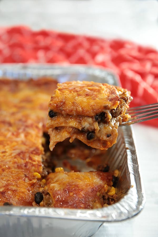 Easy Mexican Beef Lasagna - it's a Taco Tuesday favorite with layers of seasoned ground beef, tortillas, black beans, salsa and mounds of melted cheese. A freezer meal that's ready to just pop in the oven! #mustlovehomecooking