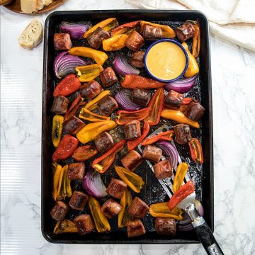 Delicious, versatile and fast, this Sheet Pan Smoked Sausage and Mini Peppers tossed with olive oil is an entire meal ready in 30 minutes!