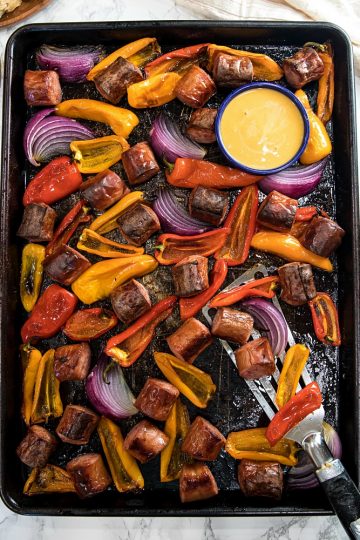 Delicious, versatile and fast, this Sheet Pan Smoked Sausage and Mini Peppers tossed with olive oil is an entire meal ready in 30 minutes!