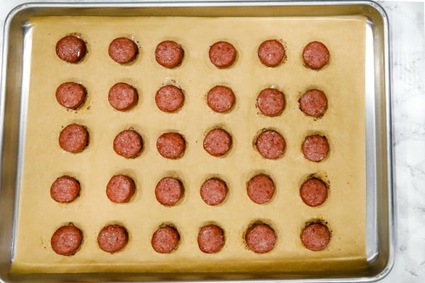 baked smoked sausage on parchment sheet on sheet pan