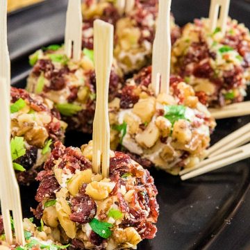 Festive bite size cheese balls take only minutes and are chock full of tangy goat cheese, cranberries and crunchy walnuts!