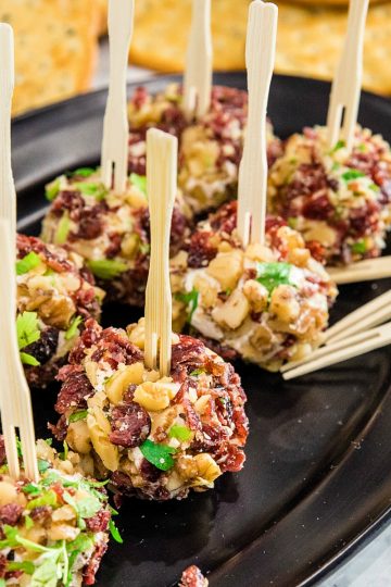 Festive bite size cheese balls take only minutes and are chock full of tangy goat cheese, cranberries and crunchy walnuts!