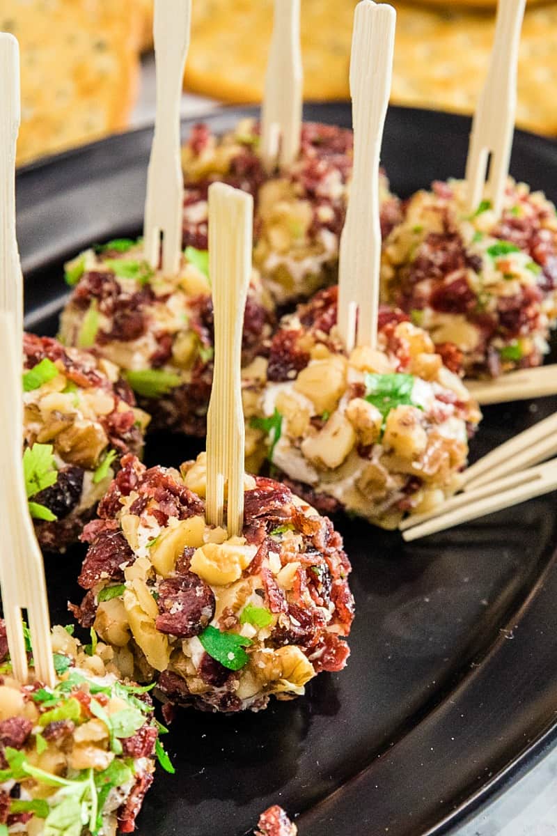 Festive bite size cheese balls take only minutes and are chock full of tangy goat cheese, cranberries and crunchy walnuts!