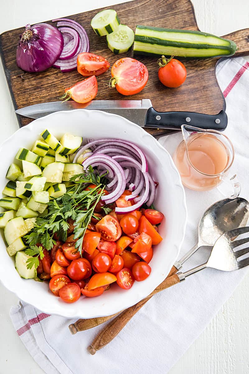 A super healthy side dish made with crisp cucumbers, tomatoes, red onion and parsley, then drizzled with a homemade sweet and sour dressing. #mustlovehomecooking