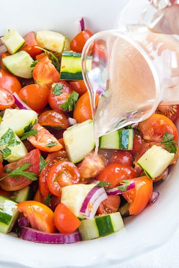 A super healthy side dish made with crisp cucumbers, tomatoes, red onion and parsley, then drizzled with a homemade sweet and sour dressing. #mustlovehomecooking