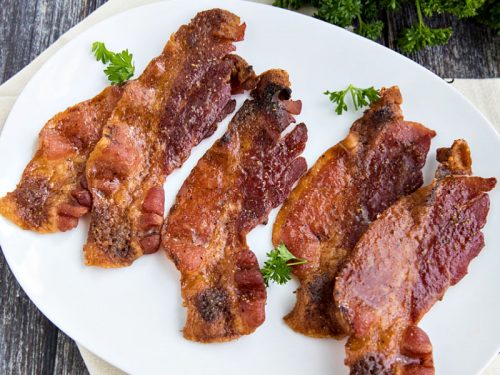 Sweet and spicy bacon cooked perfectly crisp and delicious in the oven. So easy with no mess or splatter! #mustlovehomecooking