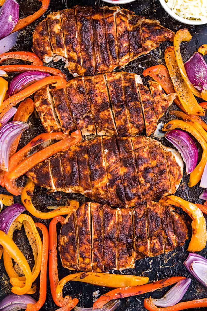 Classic chicken fajitas, with a twist, made easy on one sheet pan! An easy and delicious dinnertime favorite of juicy, adobo brushed chicken breasts, fresh bell pepper and onions all wrapped up in a soft flour tortilla. #mustlovehomecooking #mexicandinner #sheetpanrecipe