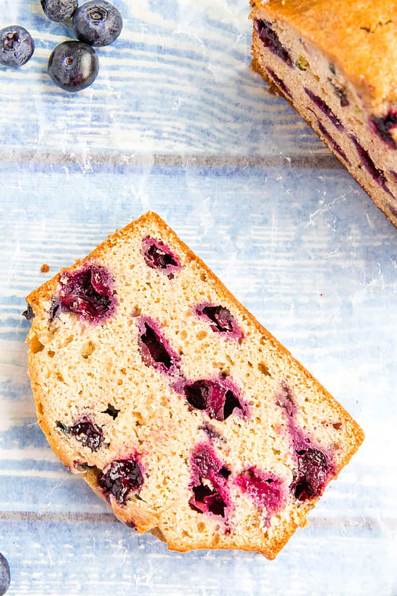 Blueberry Zucchini Bread is super simple and easy to make from scratch! This moist quick bread is made healthy with bursting blueberries, fresh zucchini and applesauce. #mustlovehomecooking