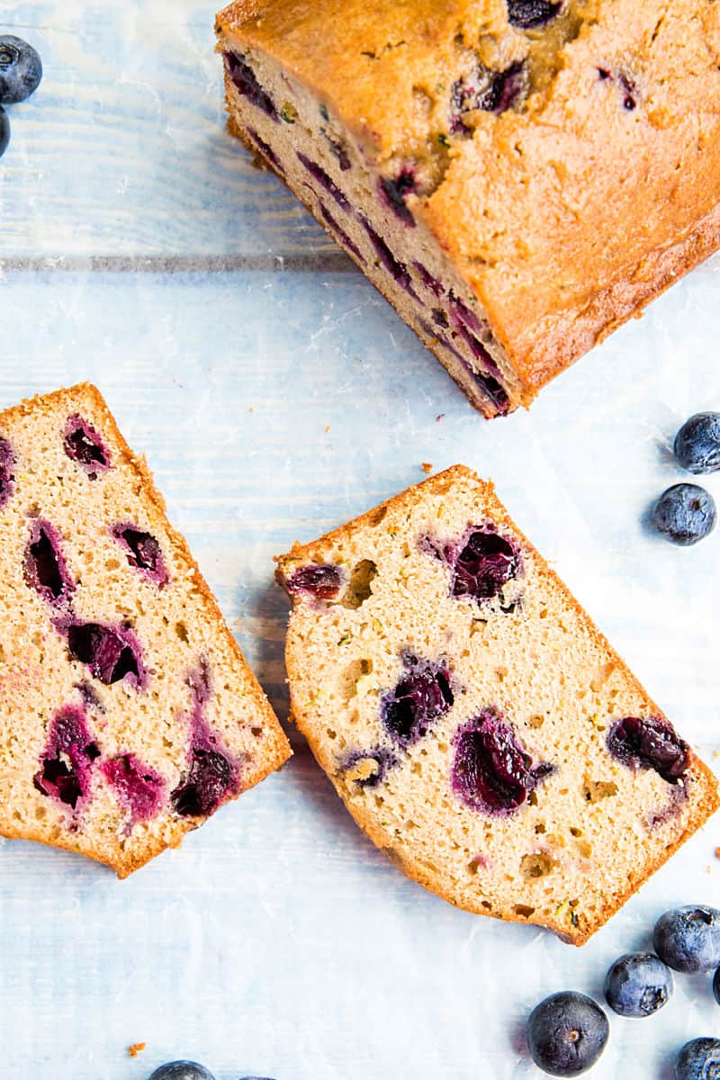 Blueberry Zucchini Bread is super simple and easy to make from scratch! This moist quick bread is made healthy with bursting blueberries, fresh zucchini and applesauce. #mustlovehomecooking