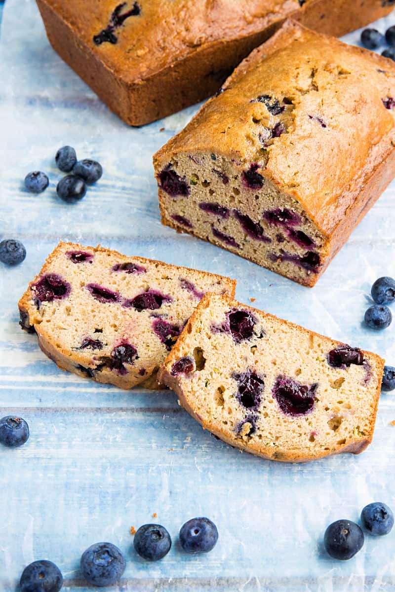 Blueberry Zucchini Bread is super simple and easy to make from scratch! This moist quick bread is made healthy with bursting blueberries, fresh zucchini and applesauce. #mustlovehomecooking