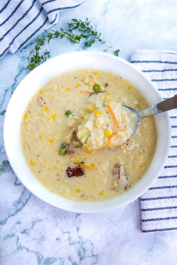 Homemade Corn Chowder is hearty, fresh and full of delicious flavors. Loaded with fresh corn kernels, tender red potatoes and crispy bacon, then finished with melting cheddar cheese and scallions. #mustlovehomecooking