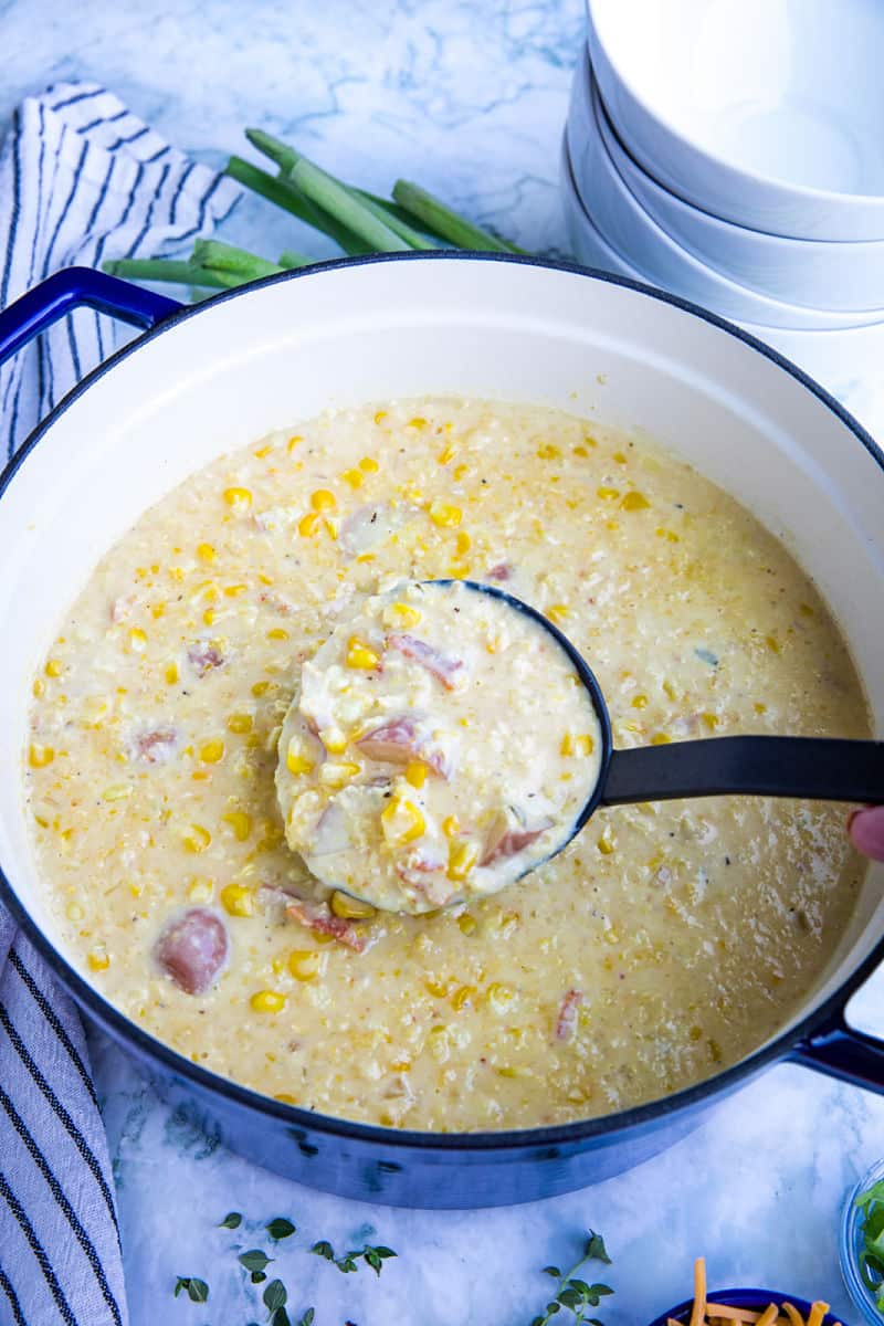 Homemade Corn Chowder is hearty, fresh and full of delicious flavors. Loaded with fresh corn kernels, tender red potatoes and crispy bacon, then finished with melting cheddar cheese and scallions. #mustlovehomecooking