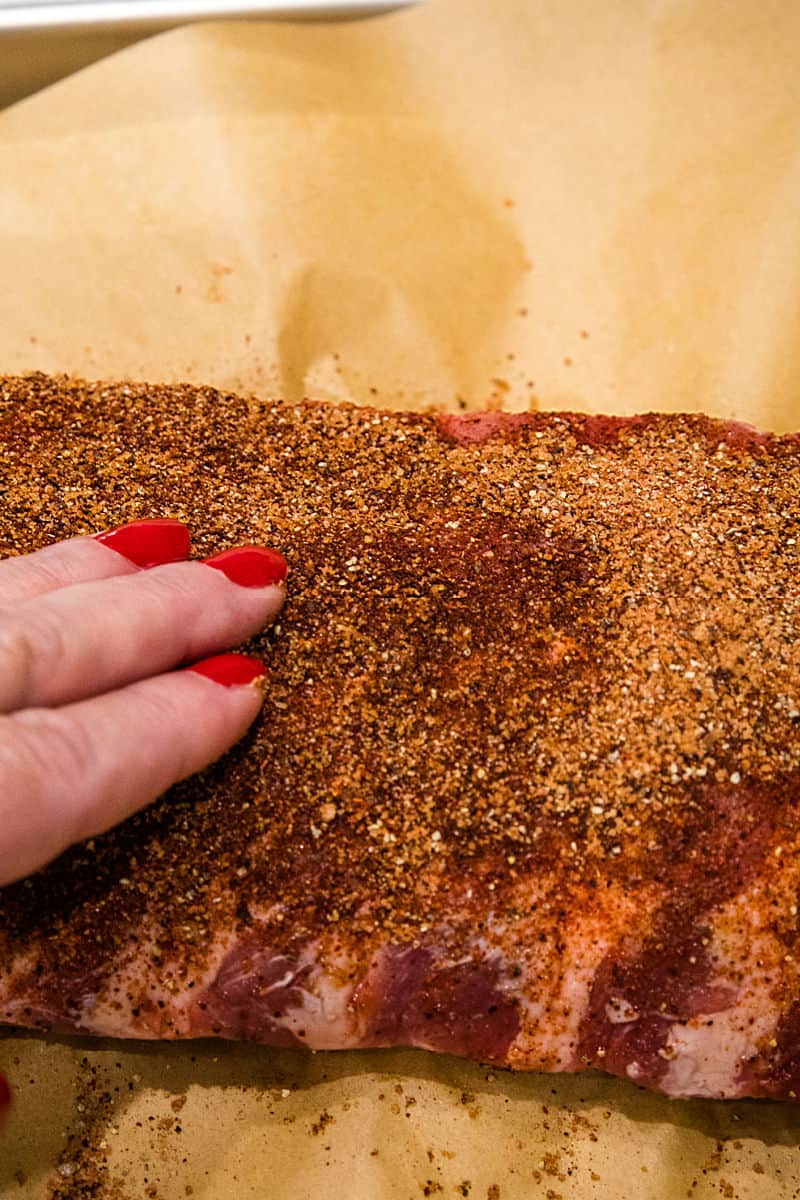 Rubbing spice mixture into rib meat.