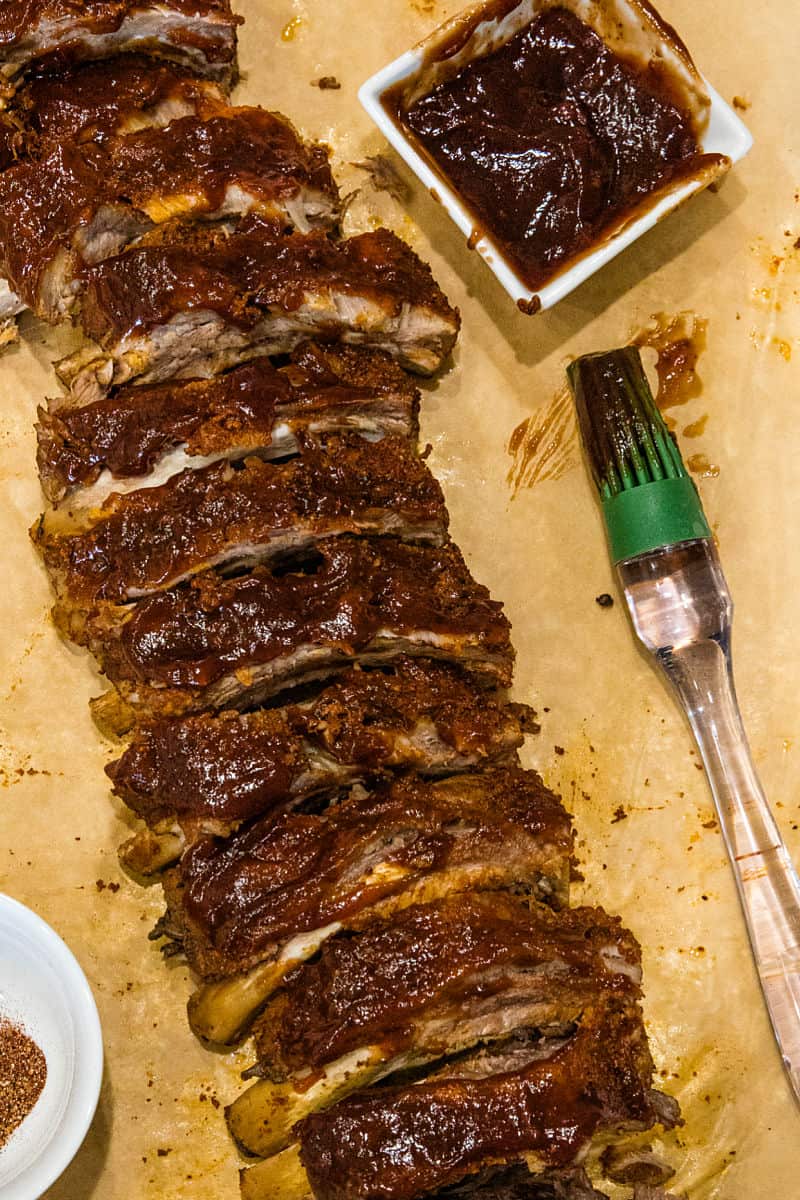 ribs slathered with sauce ready for the broiler on sheet pan