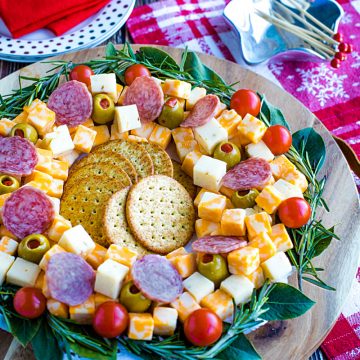 Cubed cheese, Italian sausage, stuffed olives and an abundance of seasonal herbs make this quick and easy show stopping appetizer wreath a favorite for holiday entertaining! #mustlovehomecooking