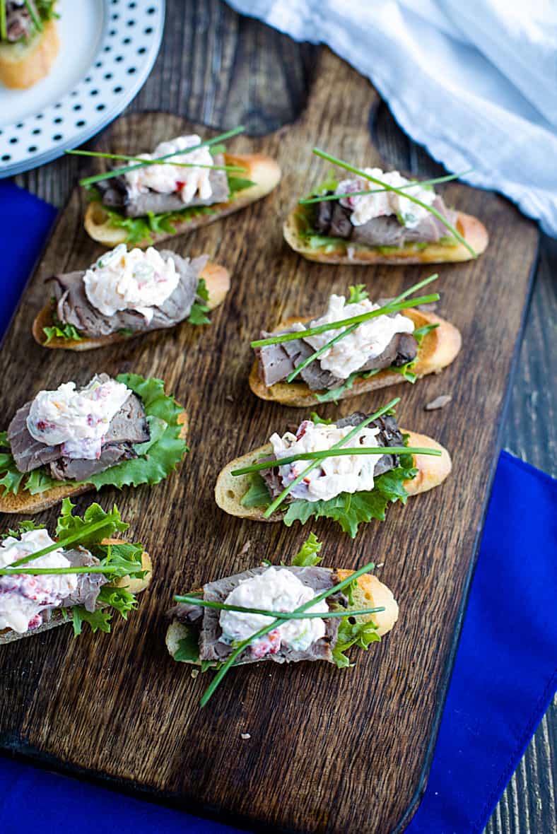 A canape' of crispy toasted bread topped with luscious roast beef and simple cheese dip. It's super simple finger food that's easy to make and perfect for the holidays! #mustlovehomecooking
