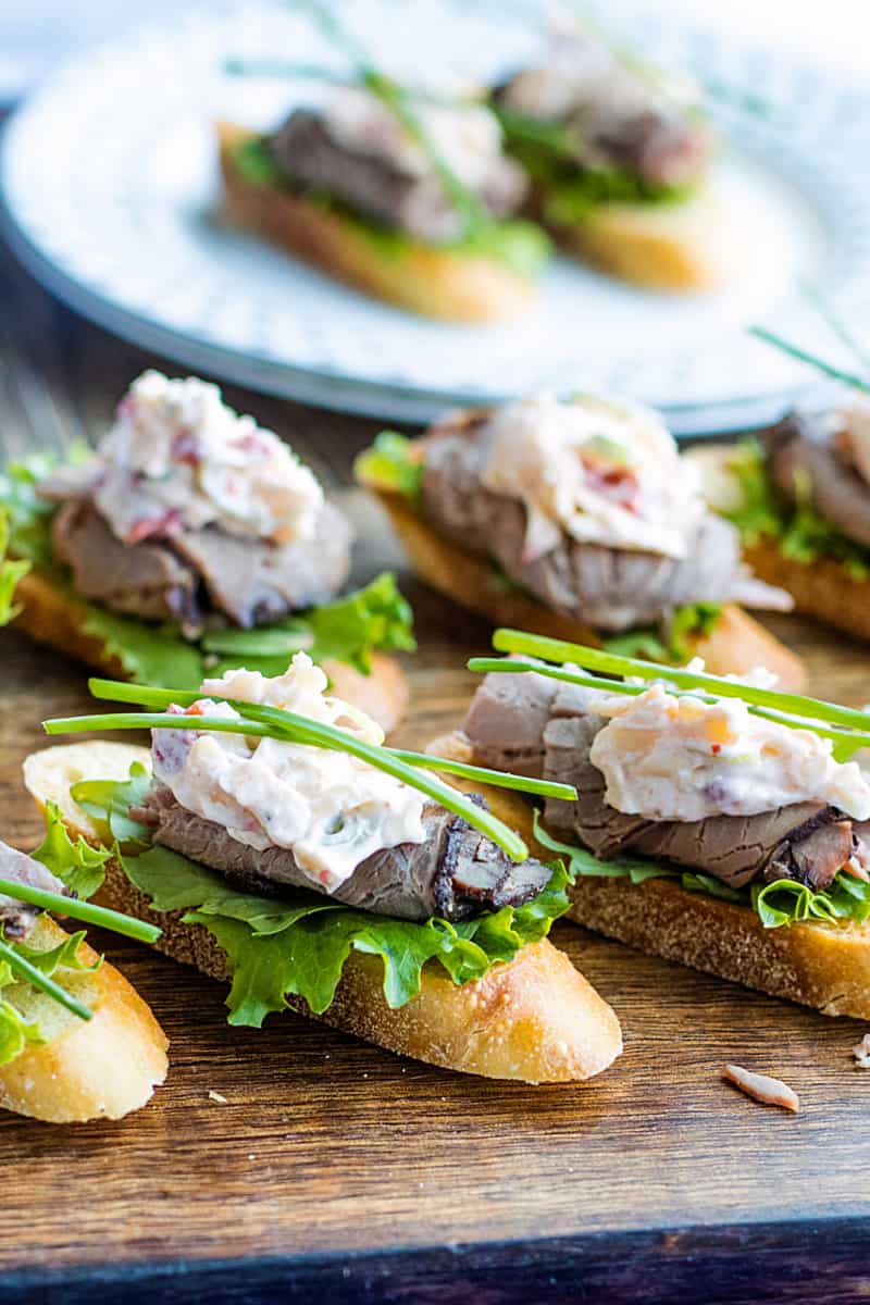 A canape' of crispy toasted bread topped with luscious roast beef and simple cheese dip. It's super simple finger food that's easy to make and perfect for the holidays! #mustlovehomecooking