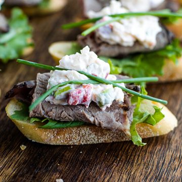 A canape' of crispy toasted bread topped with luscious roast beef and simple cheese dip. It's super simple finger food that's easy to make and perfect for the holidays! #mustlovehomecooking