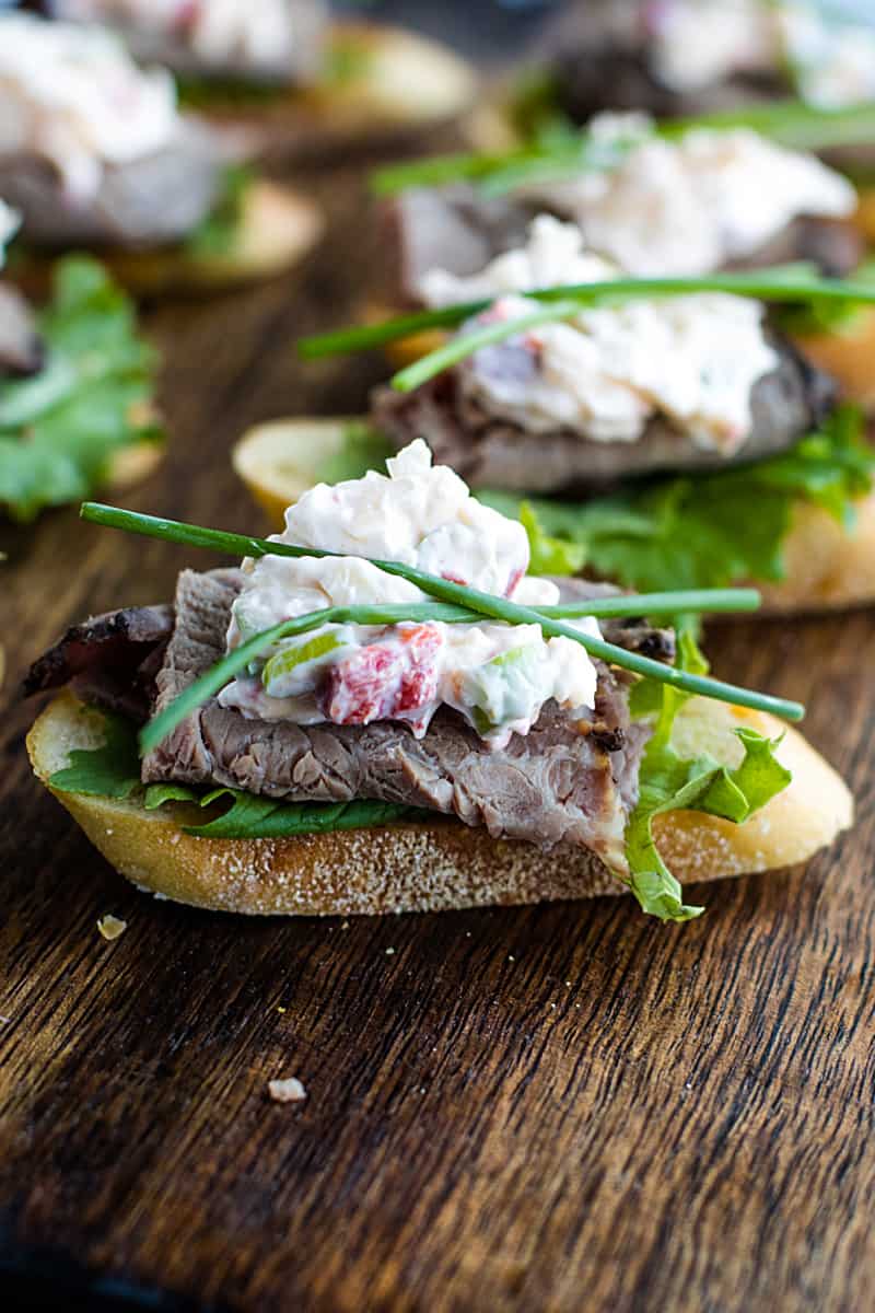 A canape' of crispy toasted bread topped with luscious roast beef and simple cheese dip. It's super simple finger food that's easy to make and perfect for the holidays! #mustlovehomecooking